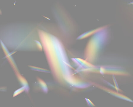 Multicolored light refraction creates dynamic shapes on a black background. The vivid prismatic streaks and beams vary in size and angle, producing a radiant optical effect.