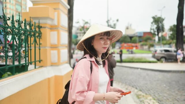 Woman Wearing Vietnamese Conical Hat Walking Outside Saigon Central Post Office in Ho Chi Minh City