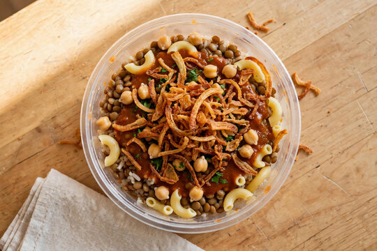egyptian koshari overhead flatlay clear bowl wooden table natural light clean