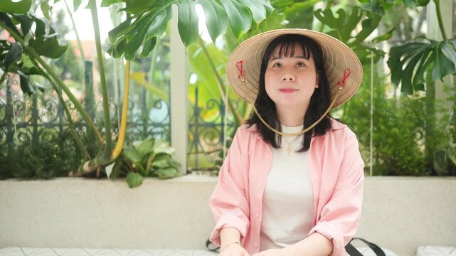Woman Wearing Vietnamese Conical Hat Sitting on a Bench in Ho Chi Minh City