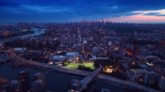 Descend over the Mott Haven neighborhood in the South Bronx, New York City. Vast scenery of the city under the dramatic cloudscape at dusk time.