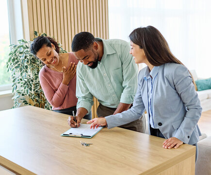 Female Real Estate Agent Selling Modern Apartment To His Young Clients , the  couple signing agreement contract  In The Fancy Apartment