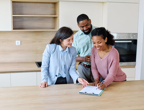 Female Real Estate Agent Selling Modern Apartment To His Young Clients , a couple signing agreement contract in the kitchen In The Fancy Apartment