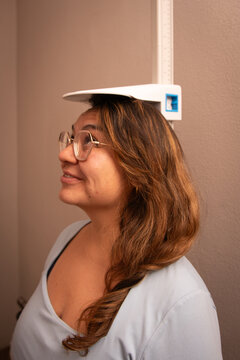 Woman standing beneath stadiometer for height measurement