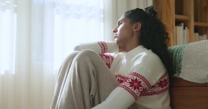 Soft light drawing African American woman sitting by window in red sweater, adjusting, seeking calm