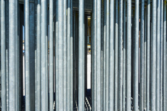 Vertical metal pipes forming a repetitive pattern background