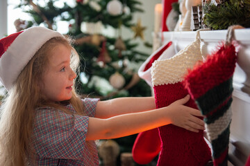 Naklejka premium Child hanging Christmas stocking joyfully.