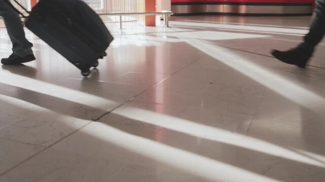 Backlit crowd walking of peoples feet and luggage while passing by in an airport