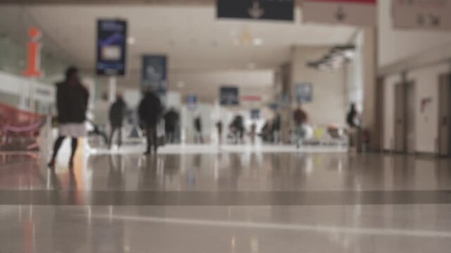 wide shot of crowd of people walking by and around in the airport graded