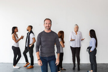 Obraz premium Diverse group of people in casual conversation against a white wall.