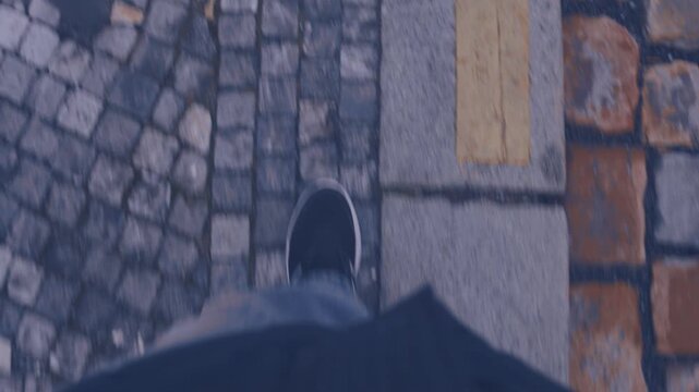 POV shot of looking down on your feet while walking on the street, taking steps