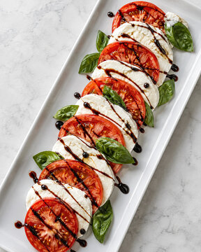 Caprese-Salat mit Balsamico auf wei&szlig;em Teller