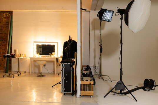 Lighting setup is standing on right side of studio with softbox, LED panel, cables