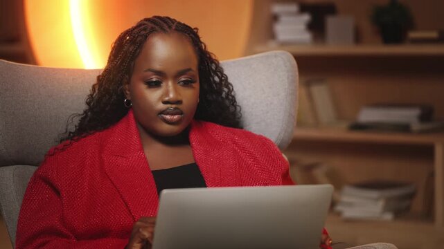 Focused African American woman works on laptop in cozy office, AI development