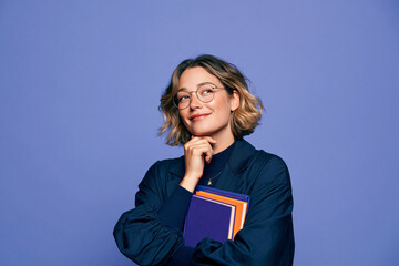 Obraz premium Thoughtful Professional Woman Holding Books in Studio