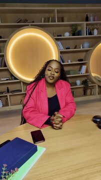 Stylish African female blogger records social media video in public library