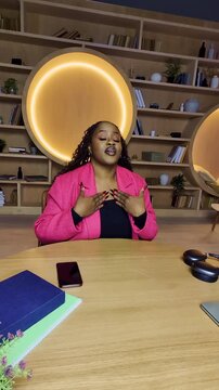 Black woman records lifestyle blog in public library, talking to followers