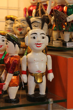 Traditional Vietnamese wooden water puppets showcasing character Chu Teu on a souvenir market display, Ho Chi Minh City, Vietnam.