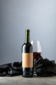 Bottle of red wine on a grey background.