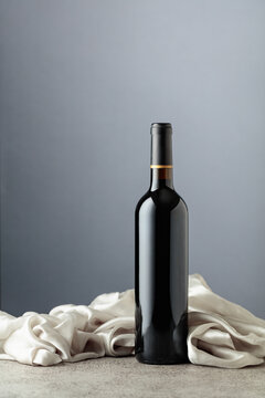 Bottle of red wine on a grey background.