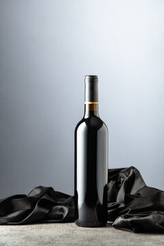 Bottle of red wine on a grey background.