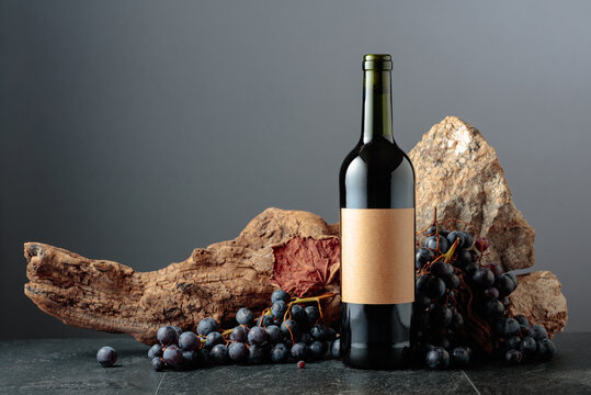 Bottle of red wine on a grey background.
