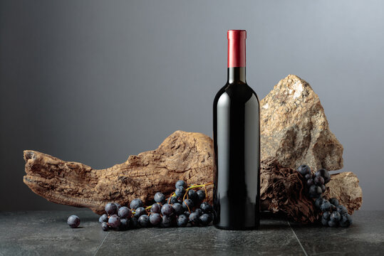 Bottle of red wine on a grey background.