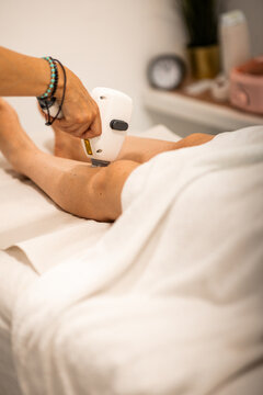 Laser epilation procedure on female leg in beauty clinic