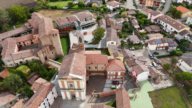 Calendasco village, Piacenza, Emilia Romagna, Italy, showcasing historic architecture with the castle, church, and residential buildings under a bright sky