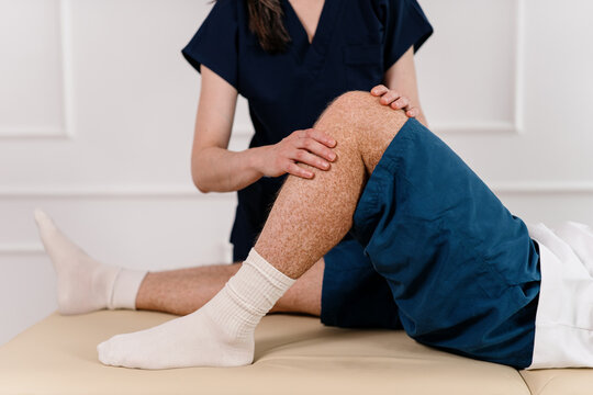 Physiotherapist assists patient with joint movement during therapy session