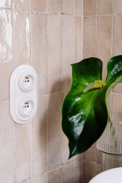 Classic white double electric socket on textured tiled wall