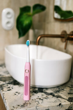 Sink with toothbrush in hotel bathroom during morning routine