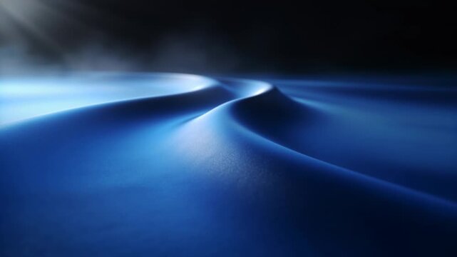 Soft light sweeping upper-left across blue dune ridge in studio, revealing granular texture