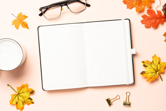 Autumn workspace. Notebook, cup of coffee and yellow leaves.