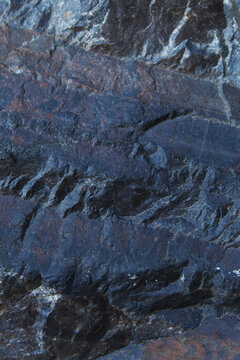 Fine grained blueish grey stone surface with subtle rust spots and cracked texture