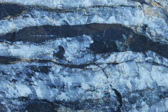 Horizontal banded gneiss rock texture featuring high contrast black and white layers