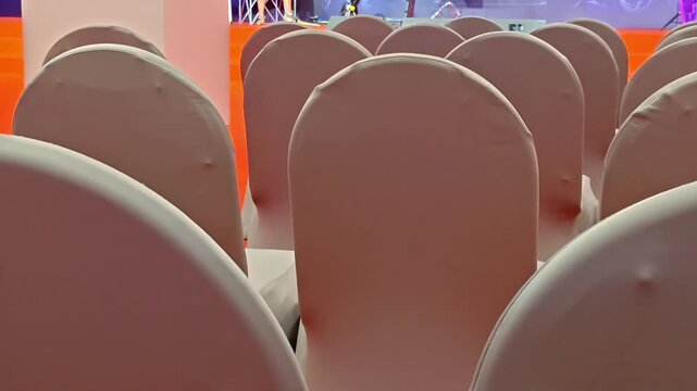 Rows of empty cloth chairs inside a hotel conference room, Celebration Guest Seating Setup, Marriage Occasion, Award Ceremony, Seat Arrangement, Elegant Festivity, Panning Shot