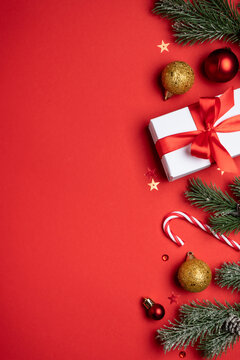 Red and white Christmas decorations and gifts on red background.