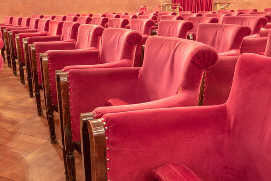 Empty Classic Red Velvet Theater Seats with Wooden Armrests
