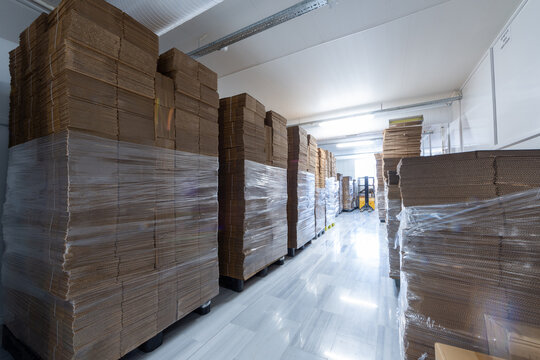 Stacked Corrugated Cardboard Boxes in Warehouse