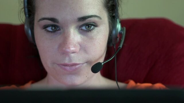 Female playing laptop games with headset on
