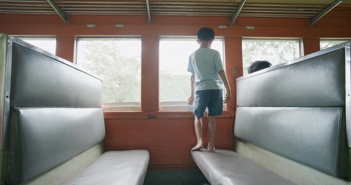 Little asian boy enjoy travel in local old train backpacker kids Thailand