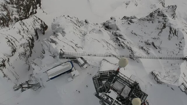 Winter aerial drone view of Mount Titlis Engelberg Switzerland featuring high alpine snowfields mountain facilities rugged peaks and spectacular Swiss Alps scenery