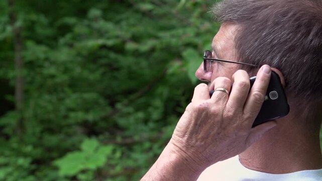 Man on phone in nature pan shot
