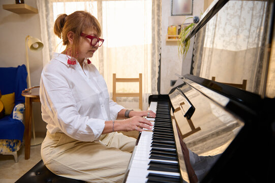 Woman practicing piano at home during a relaxed afternoon piano class