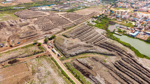 Rows of drying waste and compost windrows at an open waste segregation site