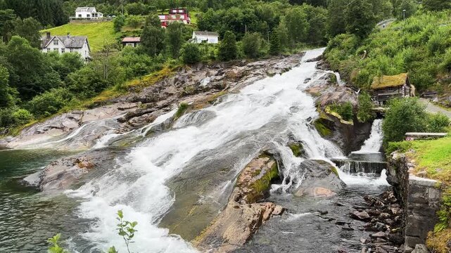 Waterfall Hellesyltfossen in Hellesylt village at overcast day, Norway