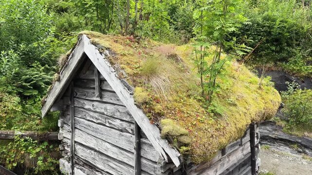 Old wooden water mill next waterfall Hellesyltfossen at overcast, Norway