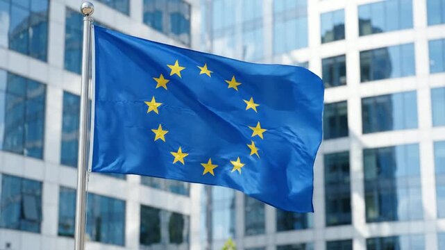 European union flag waving in front of modern corporate office building, eu politics and business concept