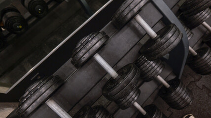 Obraz premium Row of heavy dumbbells neatly arranged on a rack in a gym setting